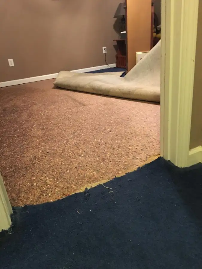 Carpet pad removal revealing water damage during Water Mitigation Services in Grayson
